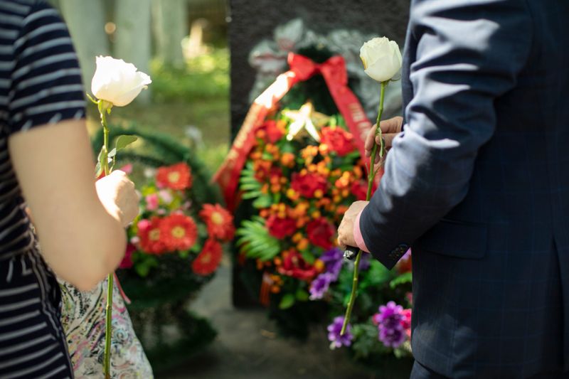 Flowers on the memorial. People lay white flowers on the burial site. A memorable event. Victory Day in Russia. A sign of respect for the fallen war heroes.