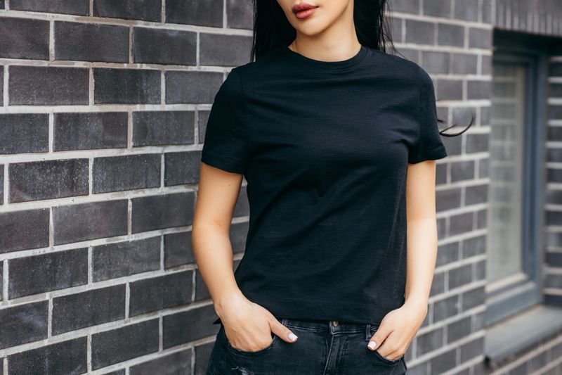 Stylish brunette asian girl wearing black t-shirt and sunglasses posing against street , urban clothing style. Street photography