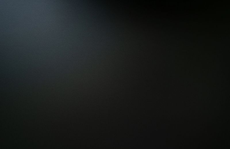 The texture of the dark black carbon slab is illuminated from the top.