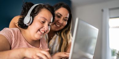 A woman and a girl enjoying time together on a laptop.