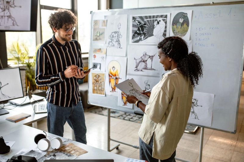Business team of computer programmers and graphic designers having meeting in the office, using white board for brainstorming and ideas.