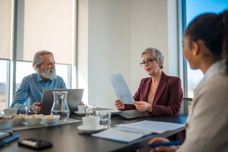 Caucasian knowledgeable female manager reading a marketing strategy. Her and the team are at a conference.