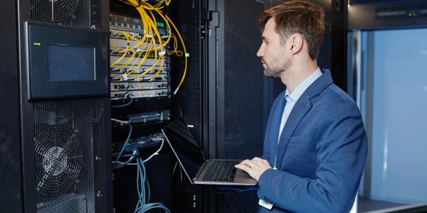 Man working on servers with a laptop.