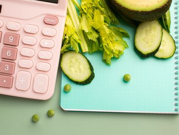 A calculator next to salad ingredients on a notepad.