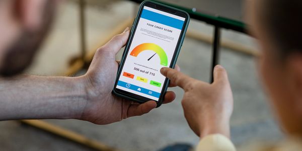 Person checking their credit score of 506 out of 715 on a smartphone.