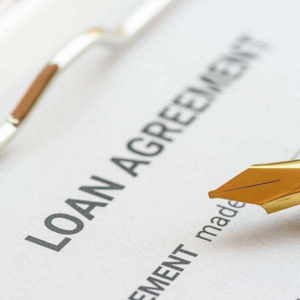 Close-up of a golden pen on a loan agreement document.