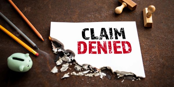 Paper with 'Claim Denied' text burnt at the bottom.