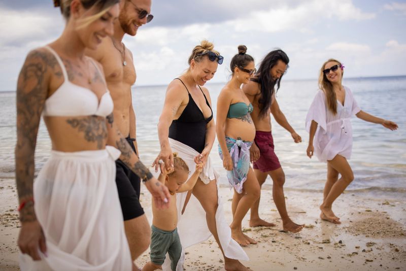 Group of multiracial female and male people walking on the beach, during their vacation