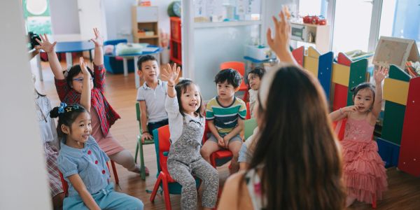 Children raise their hands during class.