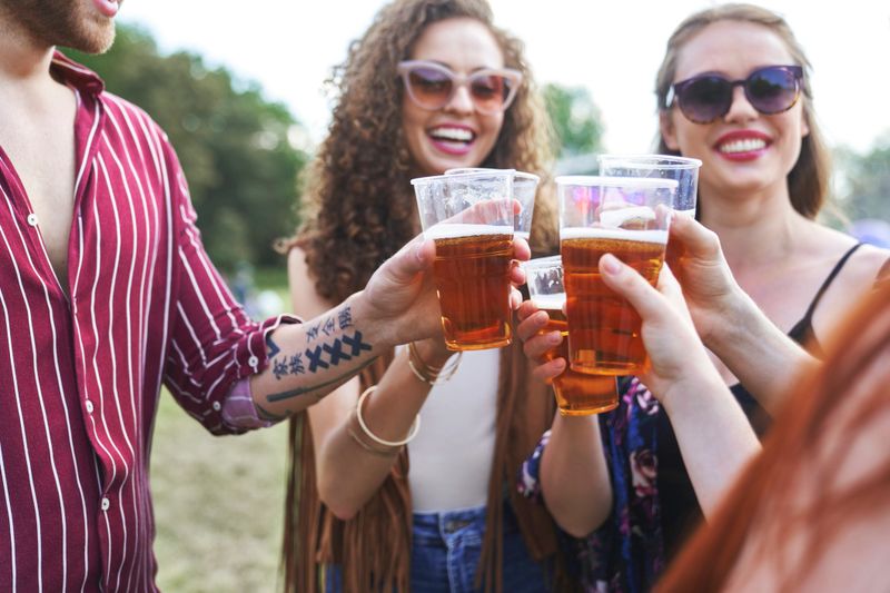 Group of caucasian friends make toasting at music festival