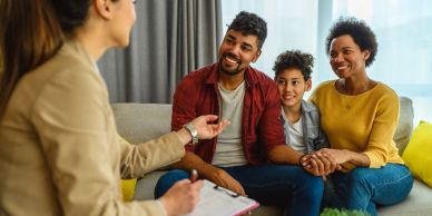 Family talking with a counselor in a cozy living room.