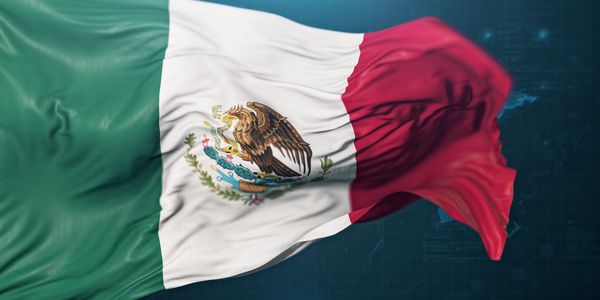 The Mexican flag waving with its emblem of an eagle on a cactus.
