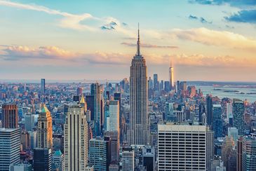 A stunning view of New York City skyline with the Empire State Building at sunset.