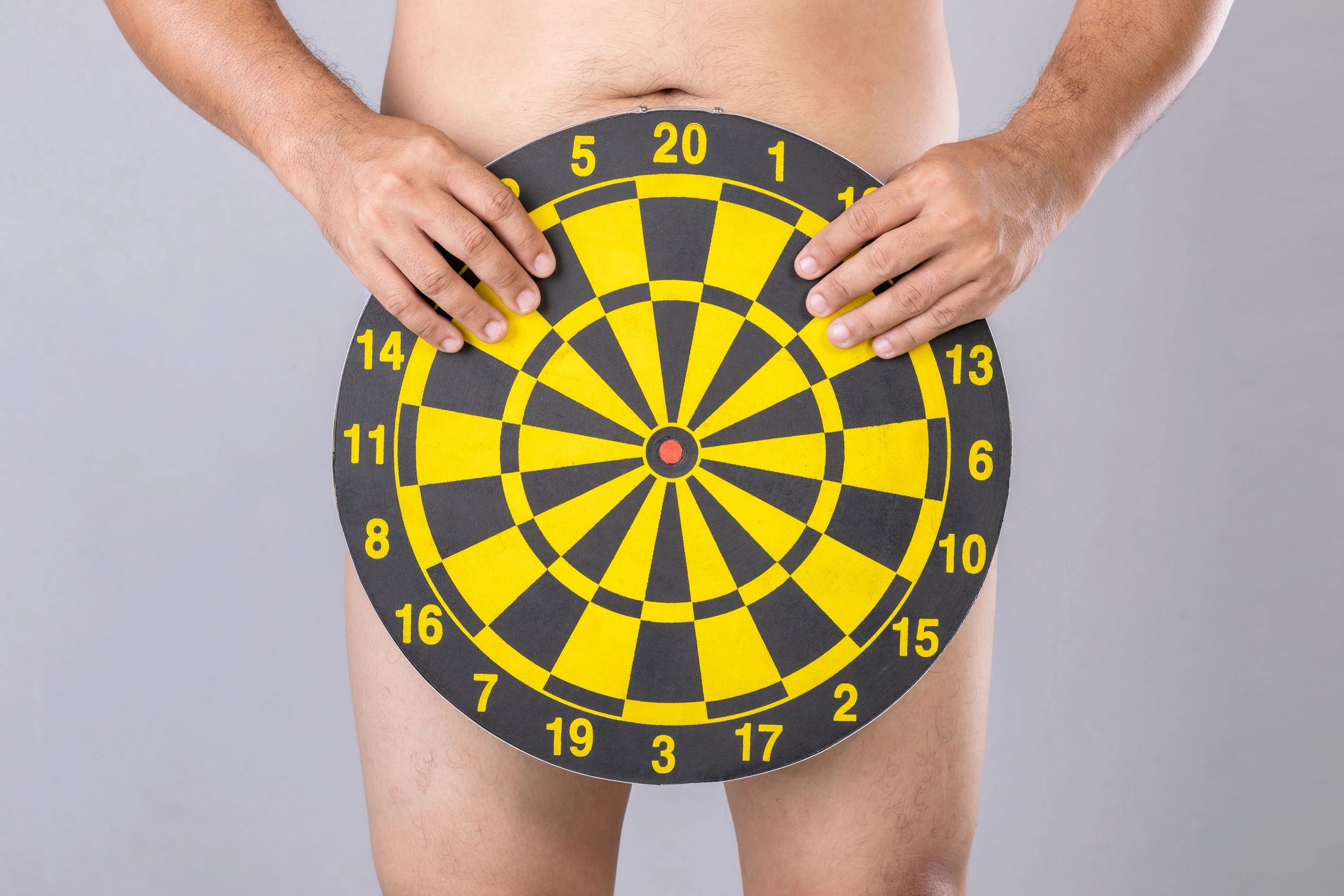 picture of man holding dart board over his private part area.