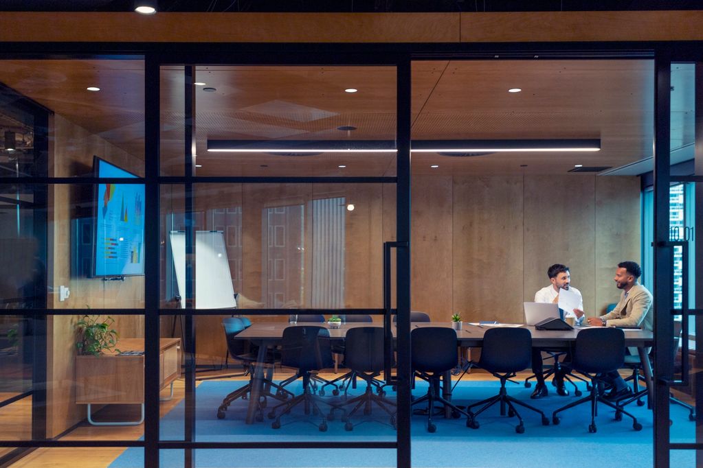 Two Men sitting in boardroom 
