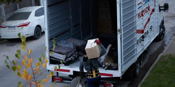 Person loading a box into the back of a truck.