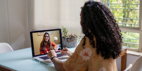 Woman video chatting on laptop at home.