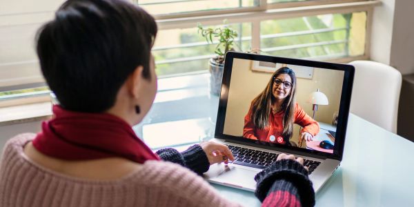 Person video calling a woman on a laptop.