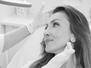Woman receiving a cosmetic facial treatment in a clinic.