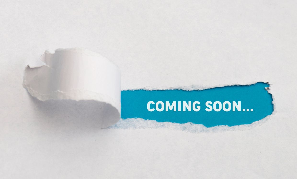 Paper torn to reveal 'COMING SOON...' message.