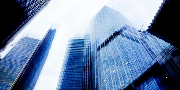 Tall glass skyscrapers reaching into the bright sky in a city.