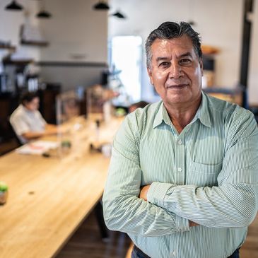 Confident man with arms crossed in modern office setting.