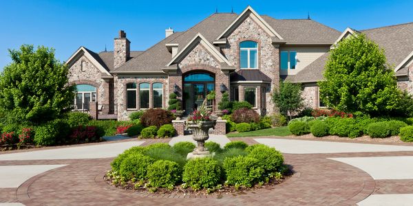 Two-story house with well-manicured lawn and evening sky.