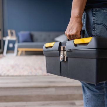 Persona con caja de herramientas en casa.