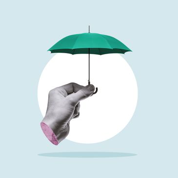 A hand holding a tiny green umbrella against a minimalist background.