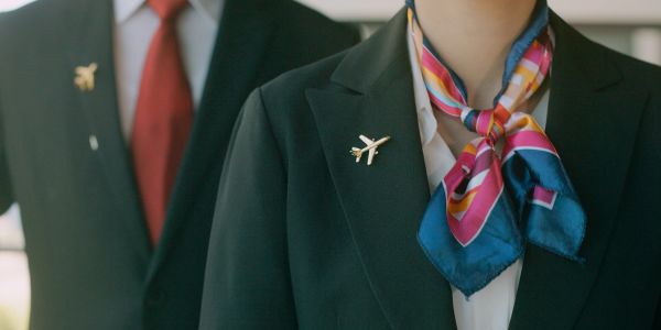 Airline employees in uniform with airplane pins.