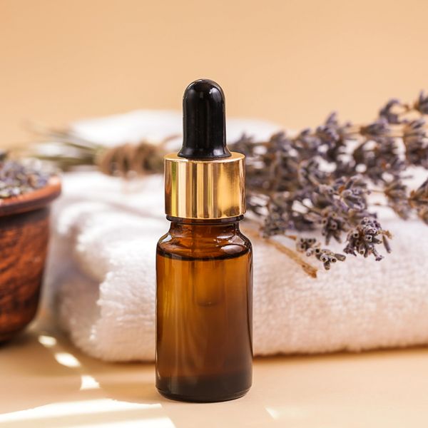 Amber glass dropper bottle with lavender and towel.