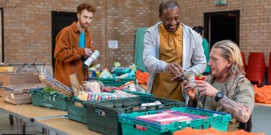 Three men sorting and distributing canned food and groceries.