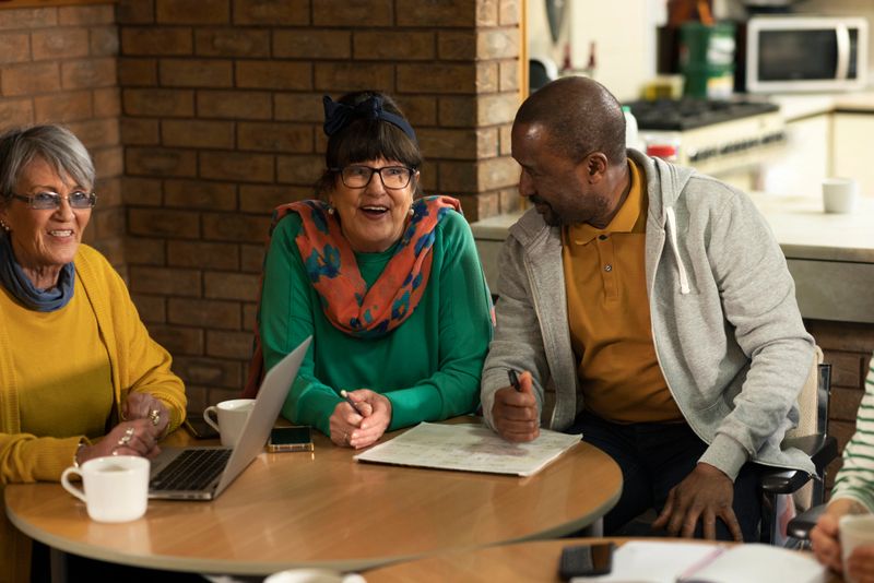 Group of volunteers hosting a meeting about their community in the North East of England. They are a diverse group and are all talking together, organising community events.