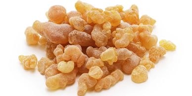 A pile of dried frankincense resin pieces on a white surface.