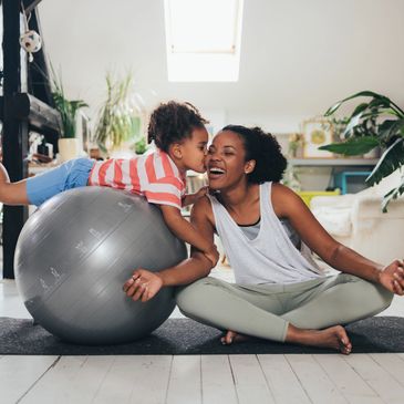 Mother and daughter share a joyful moment during home exercise.