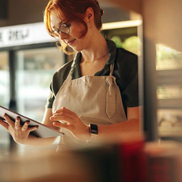 Barista using a digital tablet in a cafe.