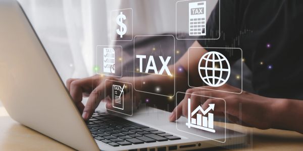 Person using laptop with digital tax icons.