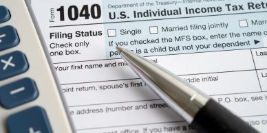 Form 1040 U.S. Individual Income Tax Return with pen.