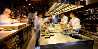 Busy restaurant kitchen with chefs working quickly.