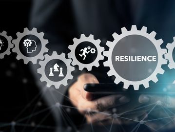 Business concepts like resilience and innovation shown with interconnected gears above a smartphone.