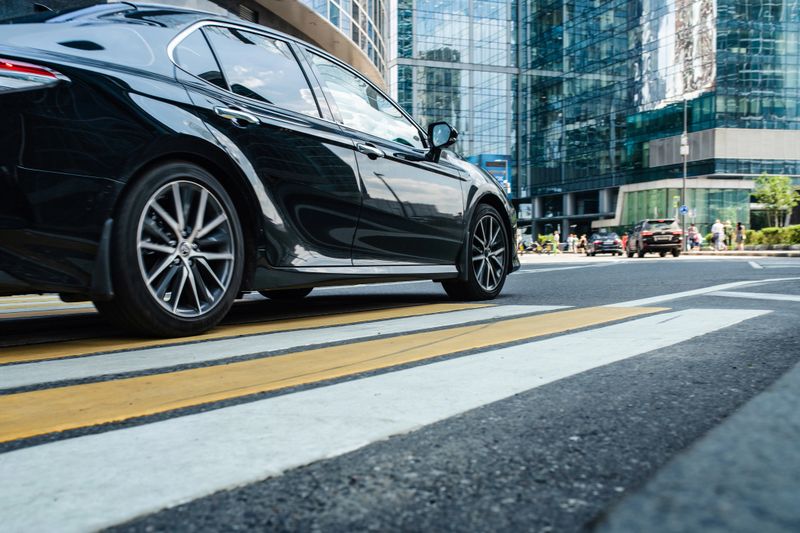 Black business car riding at the financial downtown district, blurred in motion.