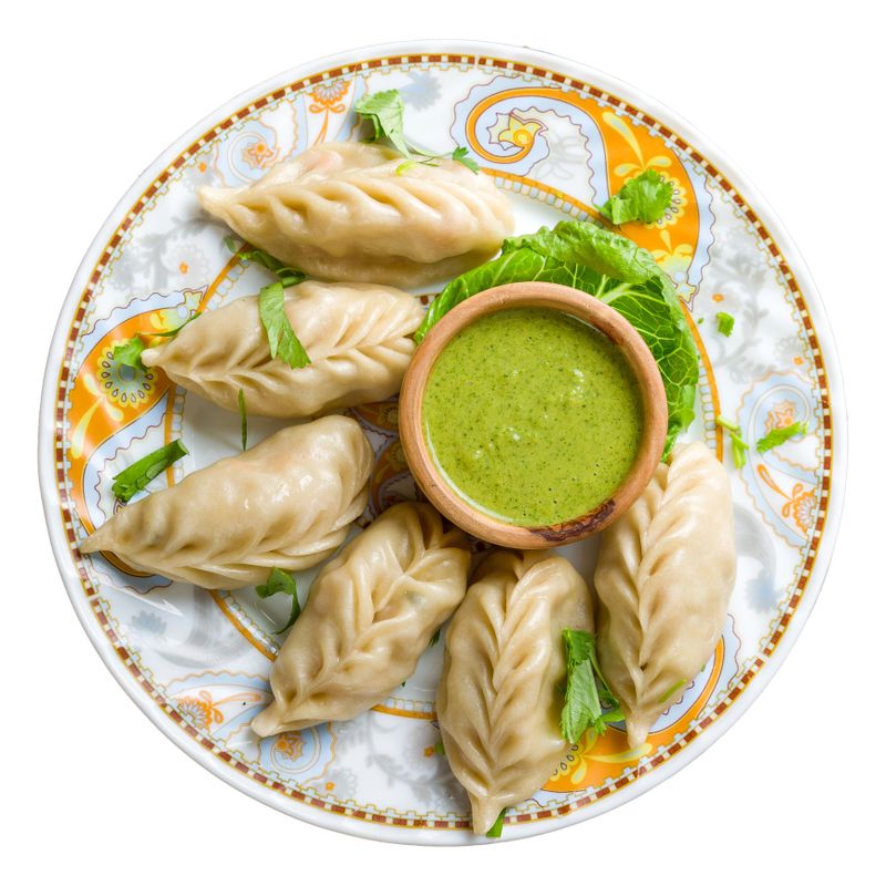 Indian food Momo with vegetables and mint sauce isolated on white background top view