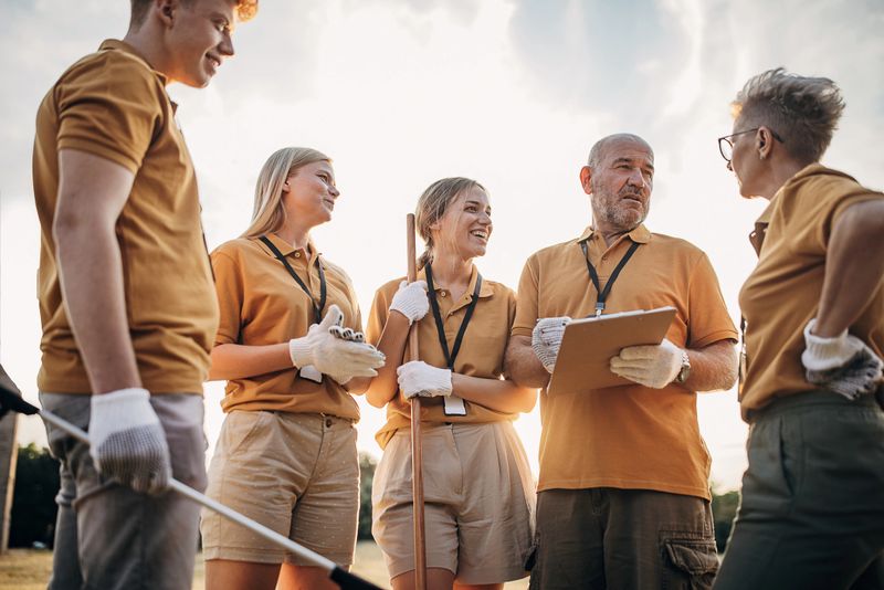 Group of volunteers talking about strategy and plans about cleaning garbage in nature