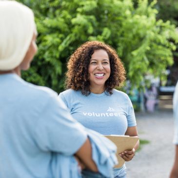 A smiling volunteer holding a clipboard.