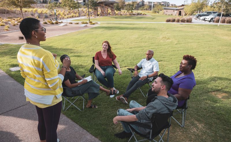 A group of people in an outdoor setting having a group therapy session