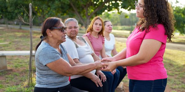 Women supporting each other outdoors.