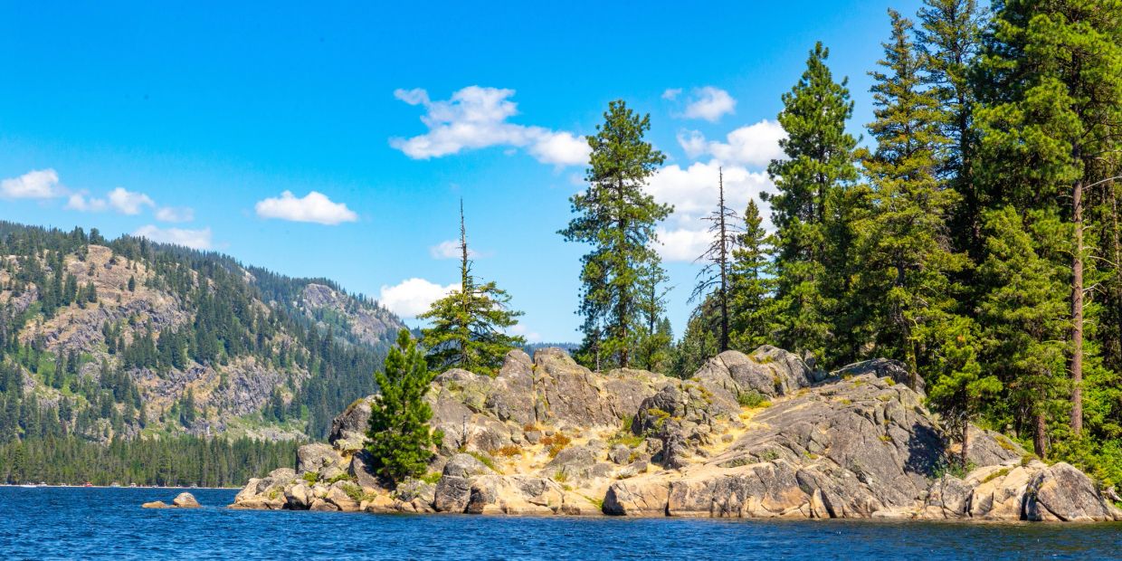 Rocky island with pine trees in a blue lake.