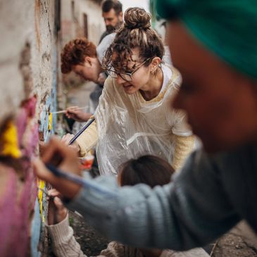 Group of people painting a wall together.