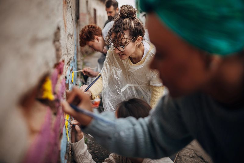 Artists collaborating on a mural in a vibrant community space.