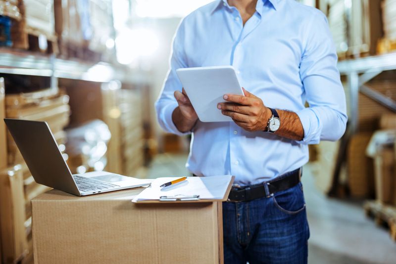 Man using a digital tablet while working in a warehouse